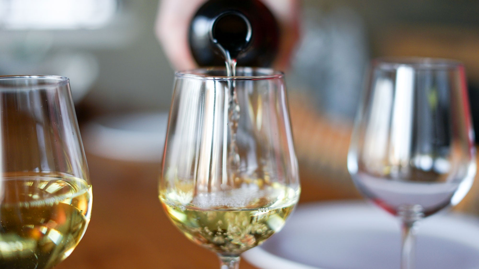 White_wine_being_poured_into_a_glass