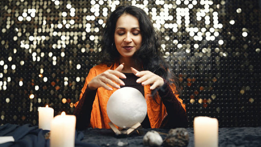 A female fortune teller waving her hands over a crystal ball